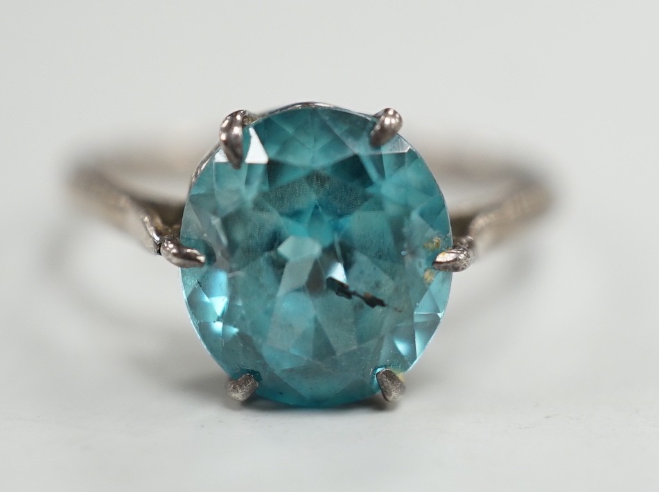 A white metal and blue zircon set ring, size P/Q, gross weight 2.8 grams.